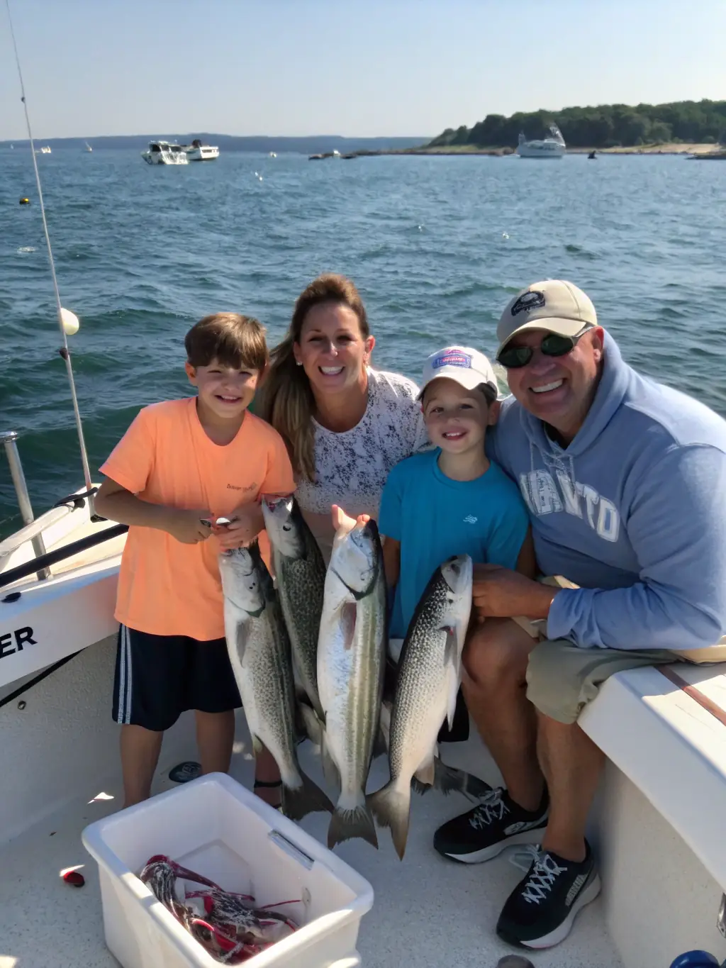 A family proudly displaying their catch of the day on a fishing trip in Cold Spring Harbor, showcasing the excitement and success of the excursion.